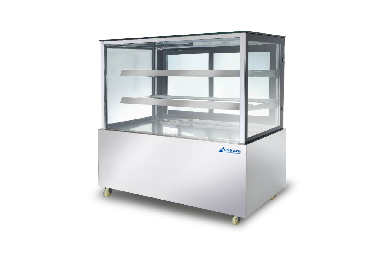 A commercial stainless steel display cabinet with clear glass panels and two interior shelves. The cabinet is branded with the Skadi logo in the bottom right corner, showcasing its sleek design, ideal for food display in retail or catering settings.