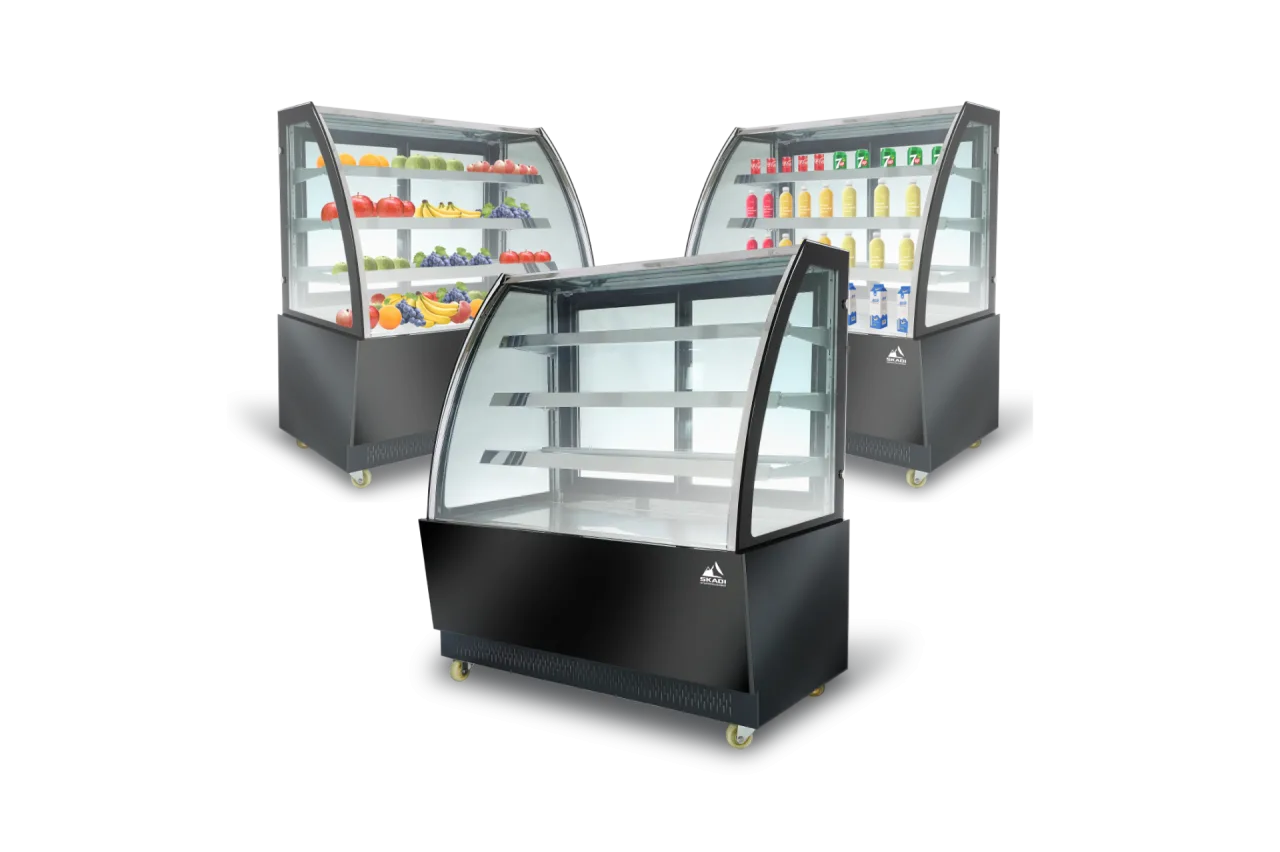 Three High-End Panoramic Cake Display Showcases | PNC-T are presented, each filled with different products. One is stocked with fresh fruits, another with beverages, and the third is empty, emphasizing the unit&#039;s versatility for various display needs.