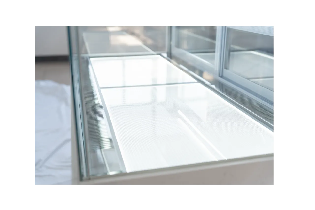 Close-up of the interior shelving of the Wide Commercial Cake Display Refrigerator | LJR, displaying the smooth glass surface and ample space for cake presentation.