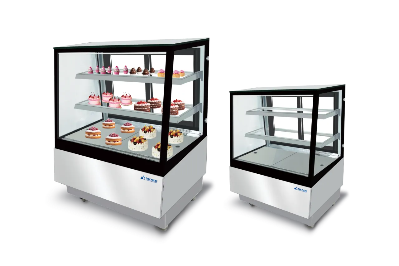 Two Compact Cake Display Showcases with Right-Angle Design | ORX-D side by side, one filled with various cakes and the other empty, showcasing the unit&#039;s capacity for displaying multiple baked goods.