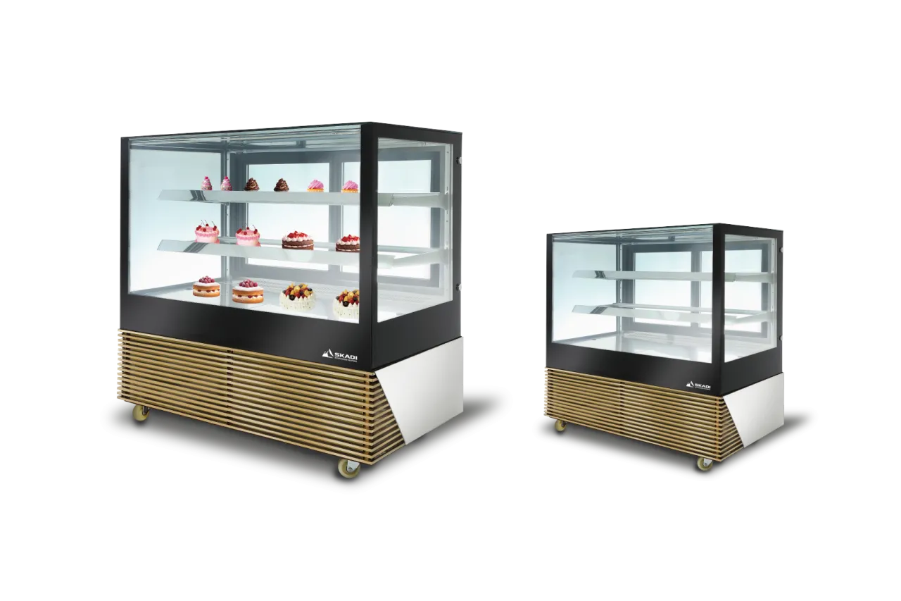 Two versions of the [High-Efficiency Commercial Cake Display Cabinet | TLR-D], both filled with an assortment of cakes and pastries on display. One is larger with more shelves, while the other is more compact. Both have sleek glass fronts and wood-paneled bases with wheels for mobility.